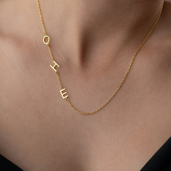 Drei Buchstaben-Kette aus 925 Silber von PIM System, detailreiche Buchstaben mit glänzendem Silberfinish, auf weißem Hintergrund.
